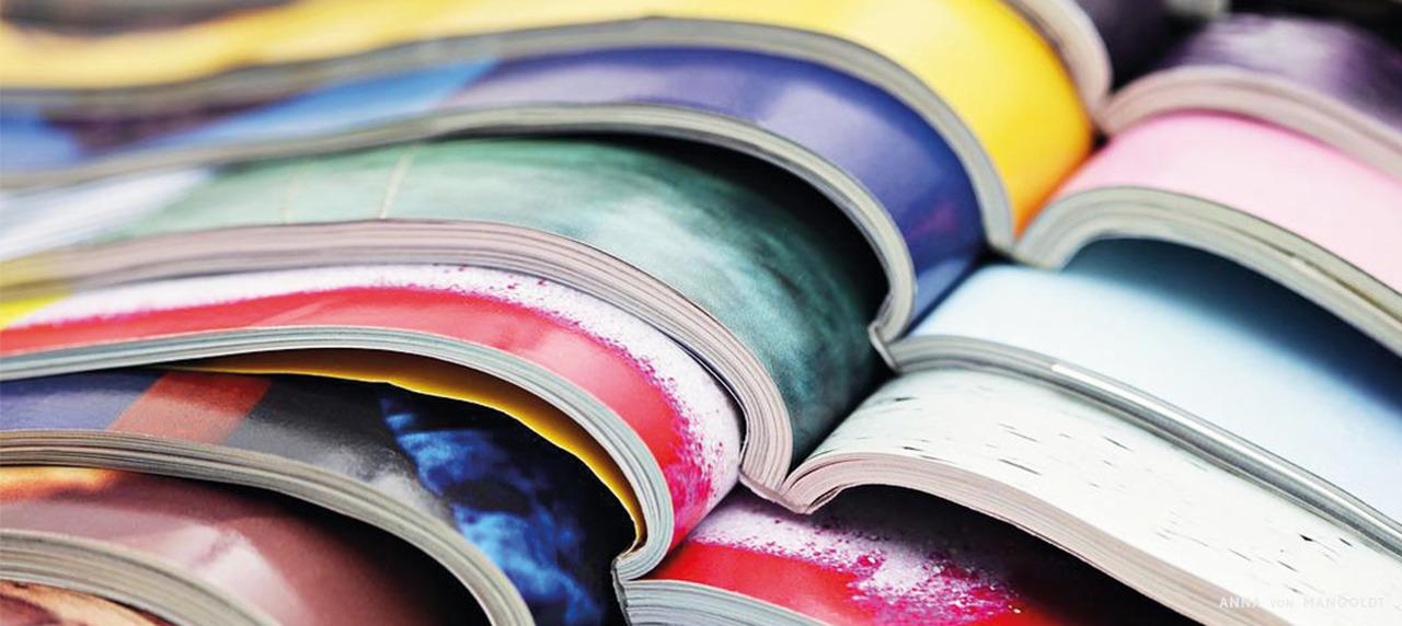 Headerbild offene Zeitschriften gestapelt