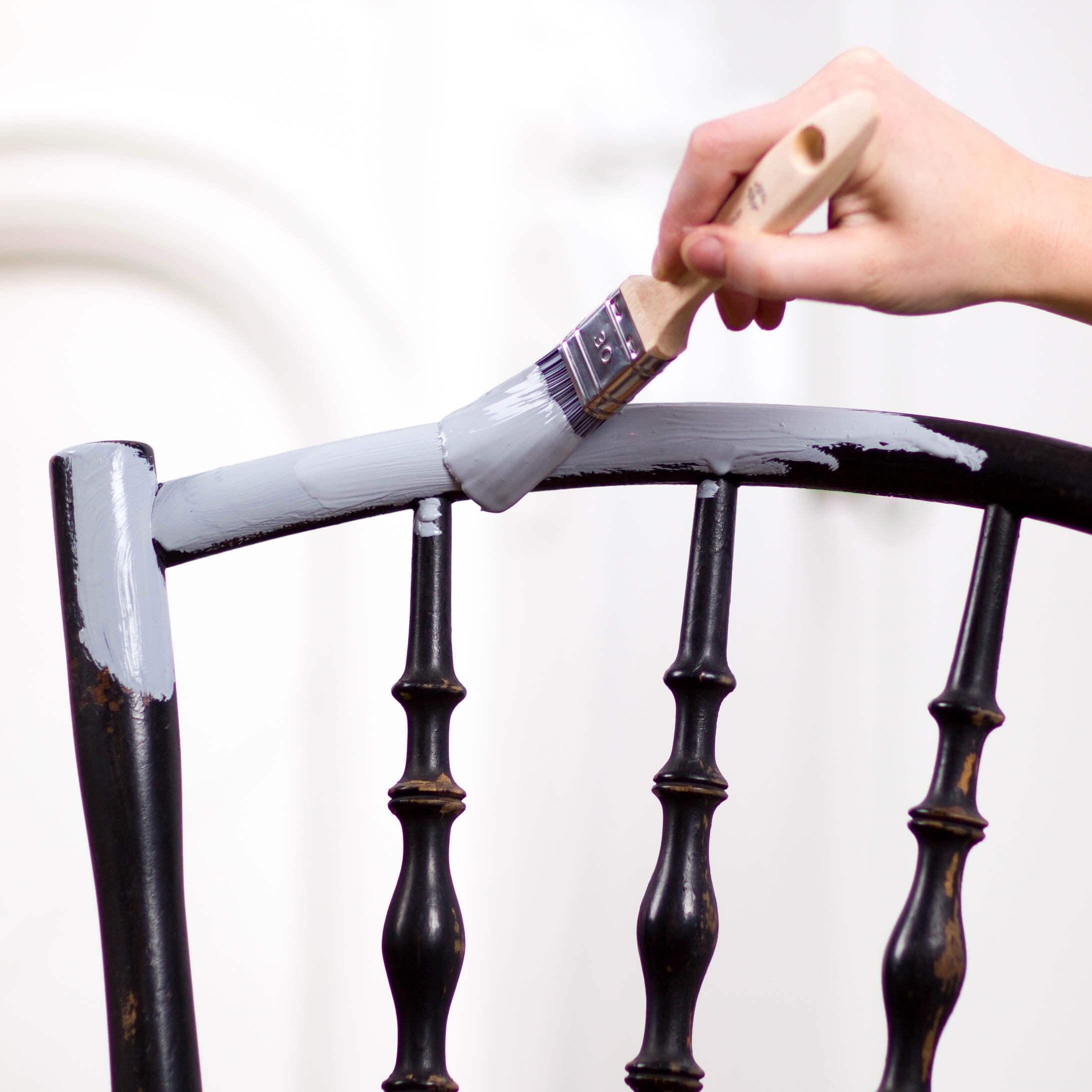 Schwarzer Stuhl wird mit hellblauer Kreidefarbe gestrichen