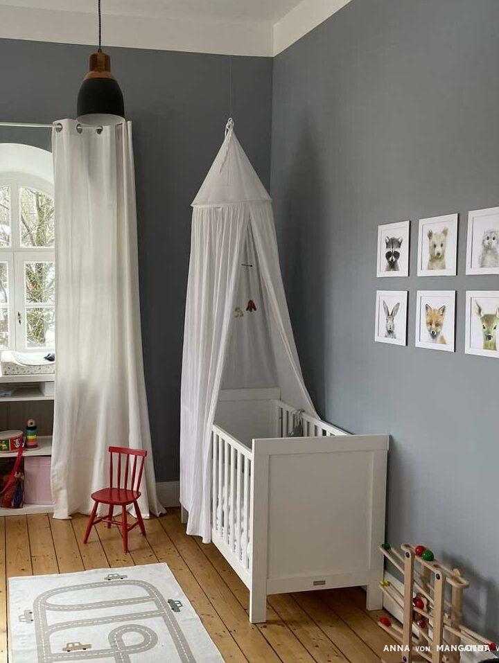 Babyzimmer mit grauen Wänden und weißen Möbeln